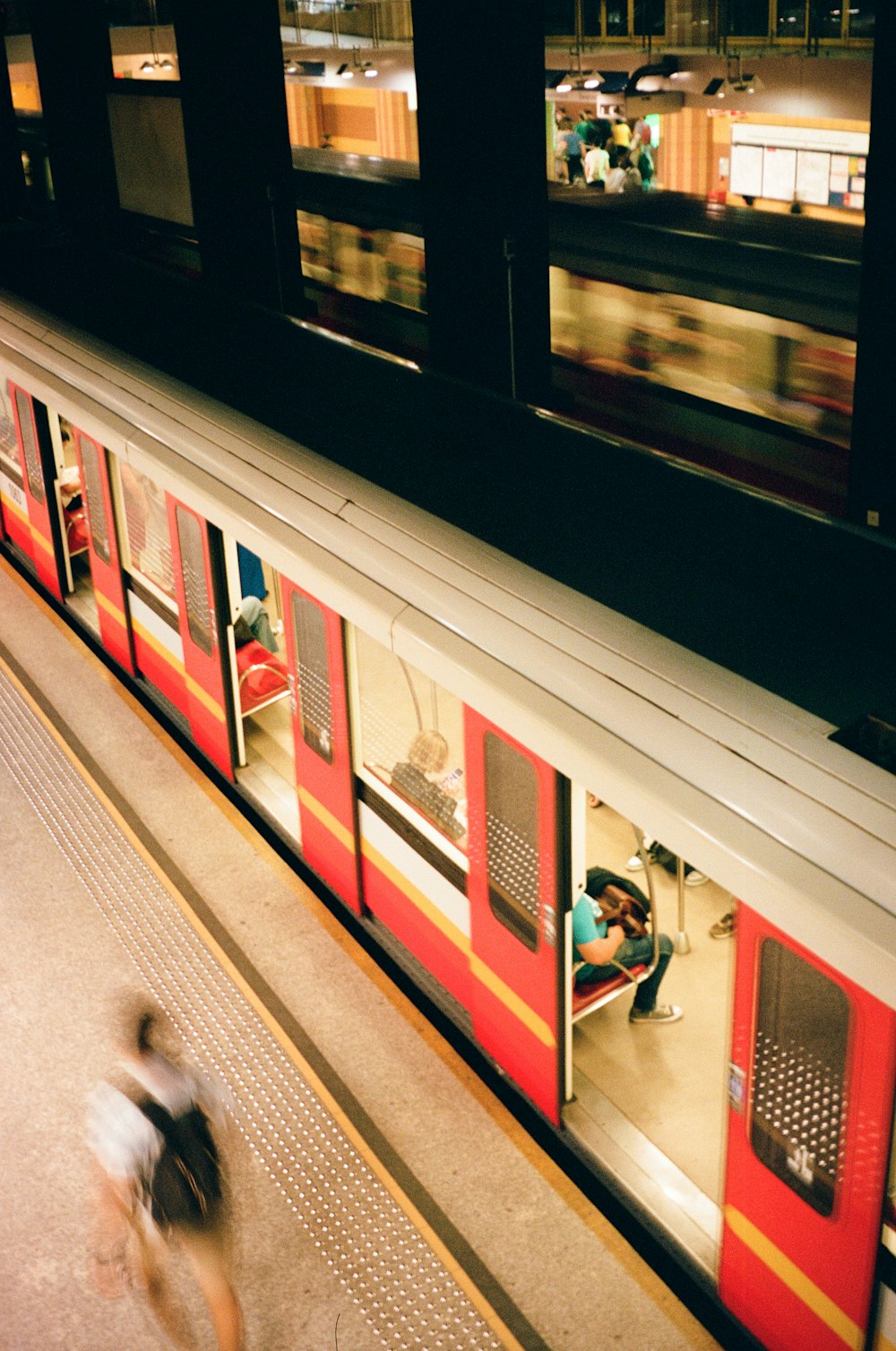 a train with people sitting on it at a train station