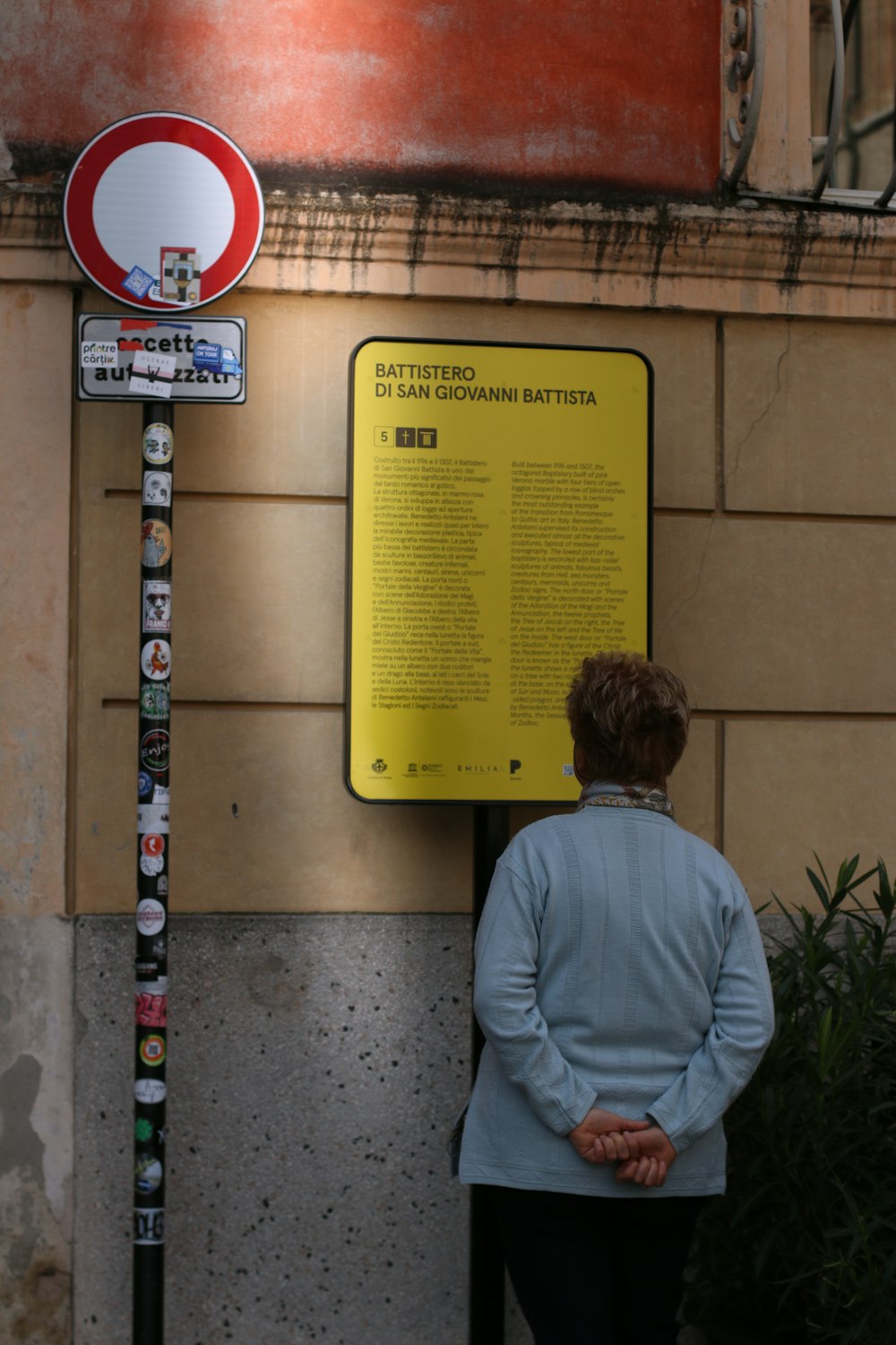 Una donna in piedi accanto a un cartello giallo