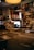 A cozy music store with rows of vinyl records organized in labeled sleeves. The shelves on the walls are filled with colorful album covers and posters. A warm lamp light adds a nostalgic ambiance.