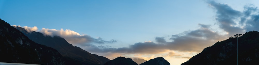 the sun is setting over a mountain range