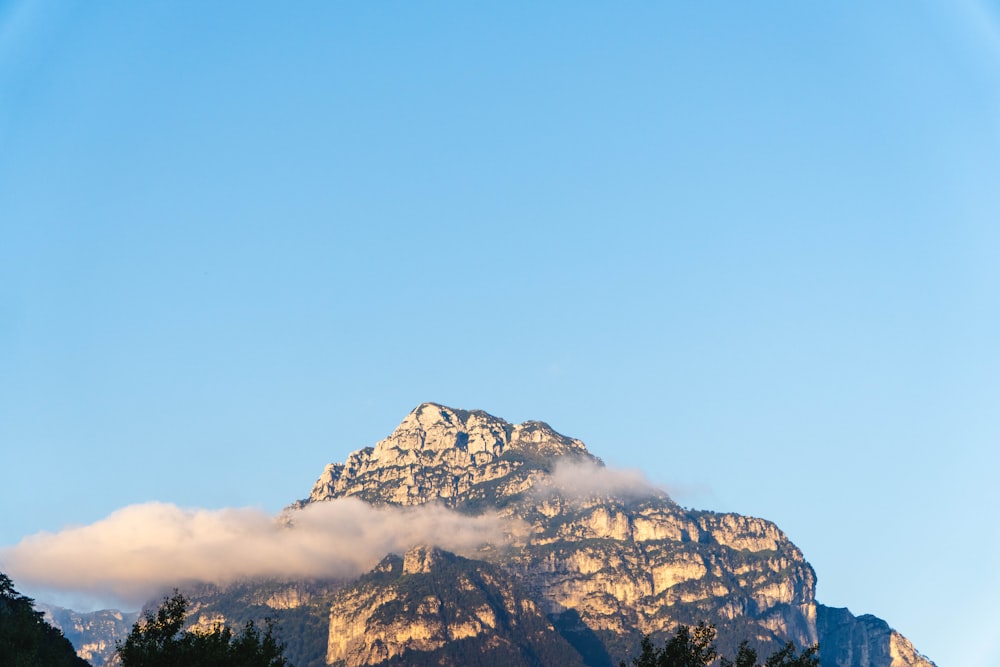 a very tall mountain with some clouds in the sky