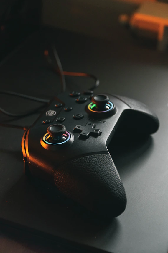 Real black gaming controller photographed on a dark desk