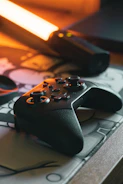 Gaming accessories arranged on a glossy surface with vibrant orange backlighting and orbital curves.