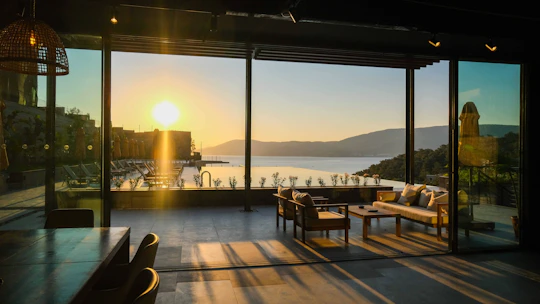 A serene spa room with soft natural light filtering through sheer curtains overlooking the lake.
