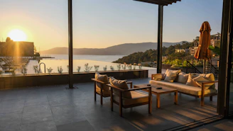 Peaceful outdoor seating area surrounded by lush greenery and lake views at sunset.