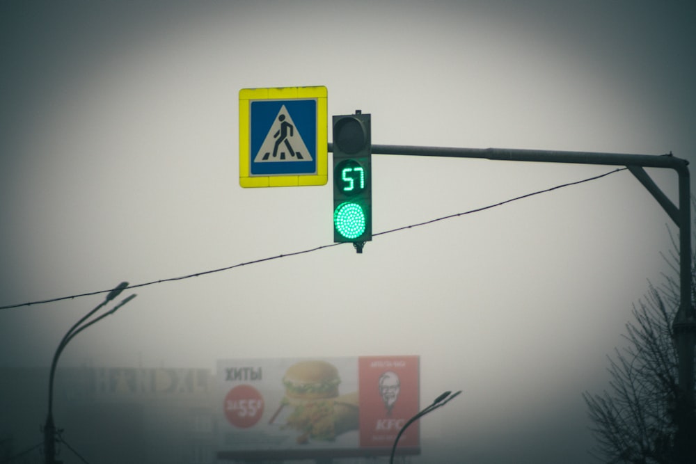 a traffic light with a green signal on a foggy day