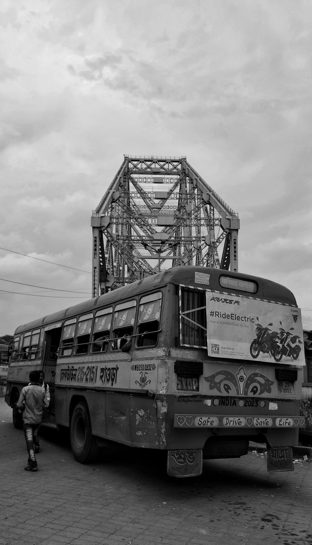 a black and white photo of a bus and a bridge