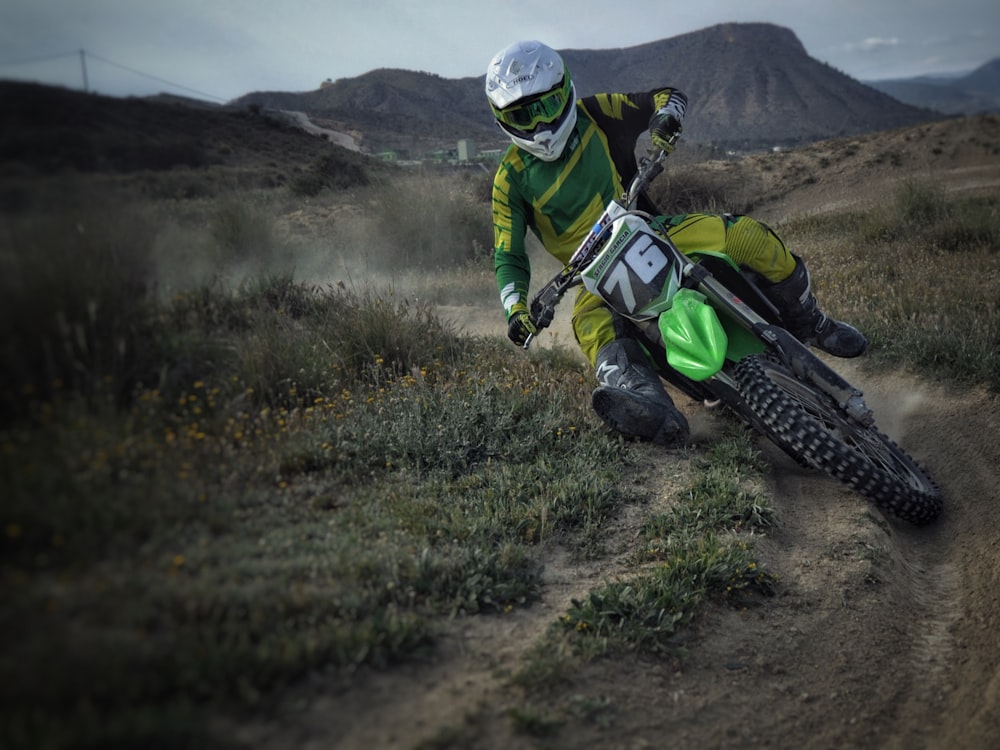 a man riding a dirt bike down a dirt road