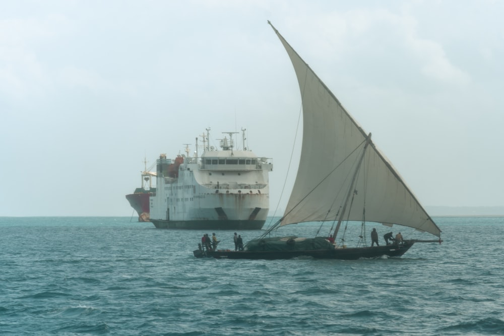 a boat with a sail is in the middle of the ocean