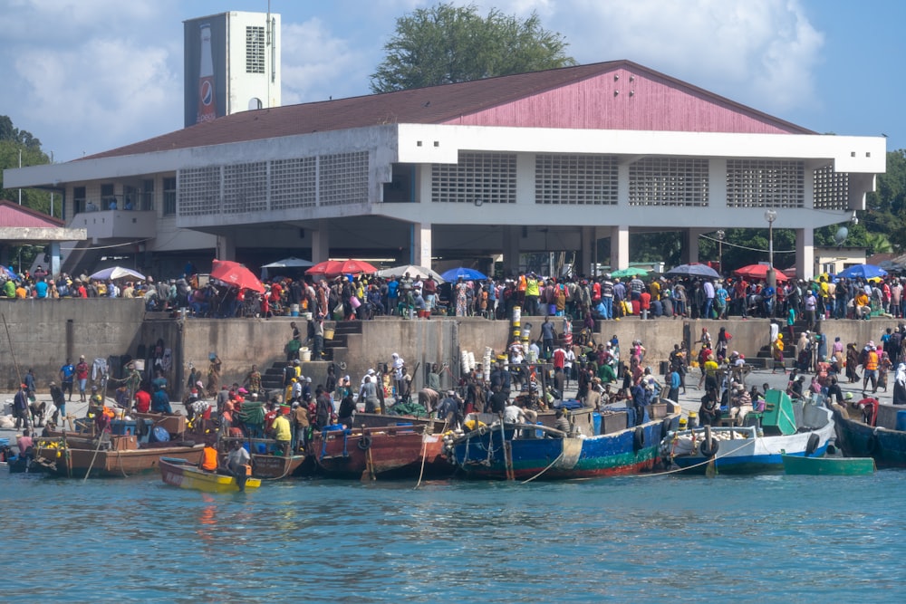 a group of people standing on a dock next to boats