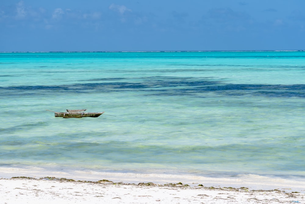 a small boat floating on top of a body of water