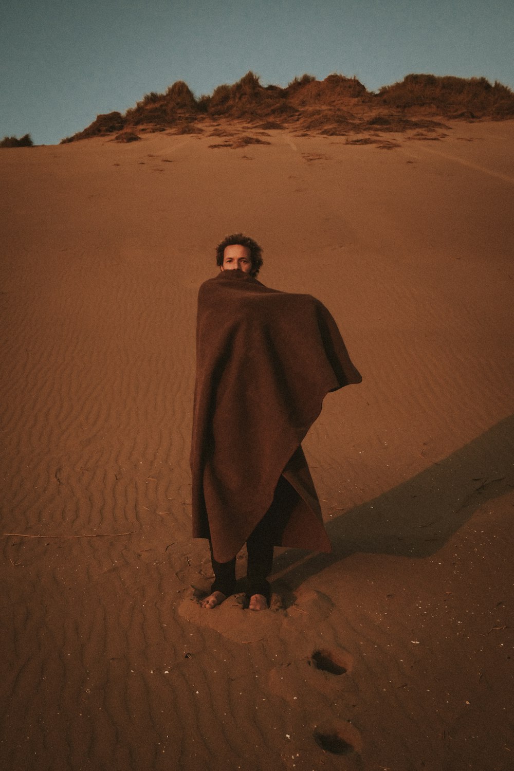 a man standing in the middle of a desert