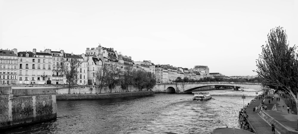 a black and white photo of a river running through a city