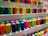 Close-up of colorful 3D printer filaments neatly arranged on display shelves.