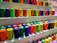Close-up of colorful 3D printer filaments neatly arranged on display shelves.