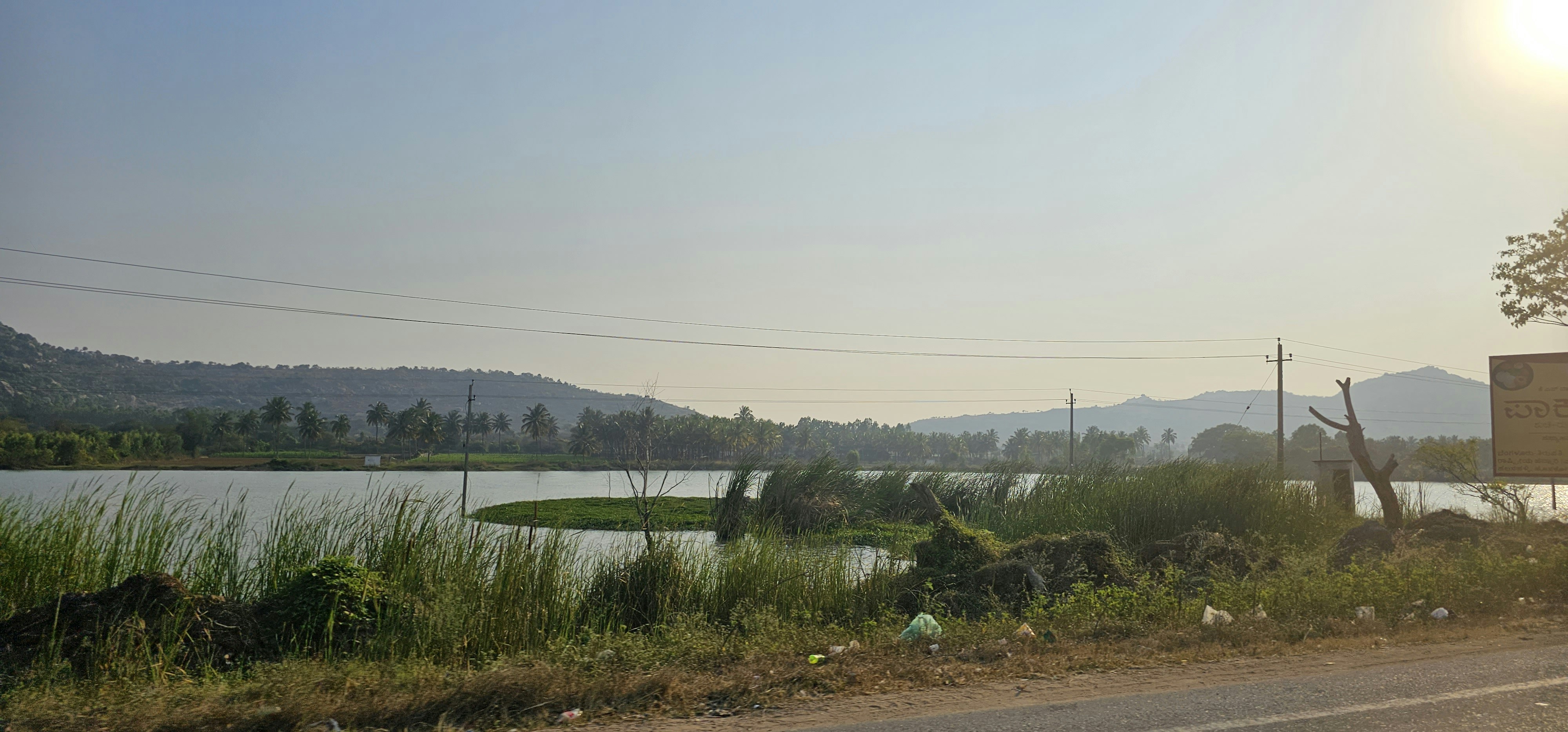 a sign on the side of a road near a body of water