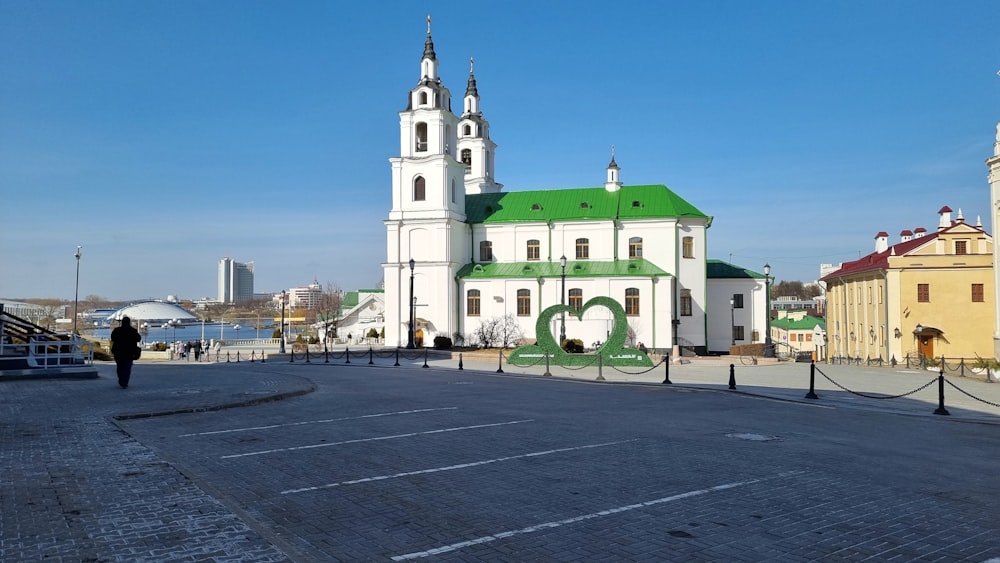 a large white building with a green roof