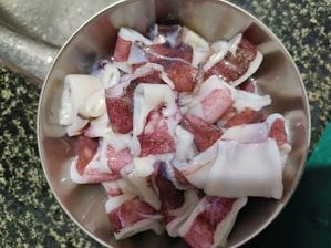 Close-up of traditional hand-pounded squid cake being prepared in a rustic kitchen setting