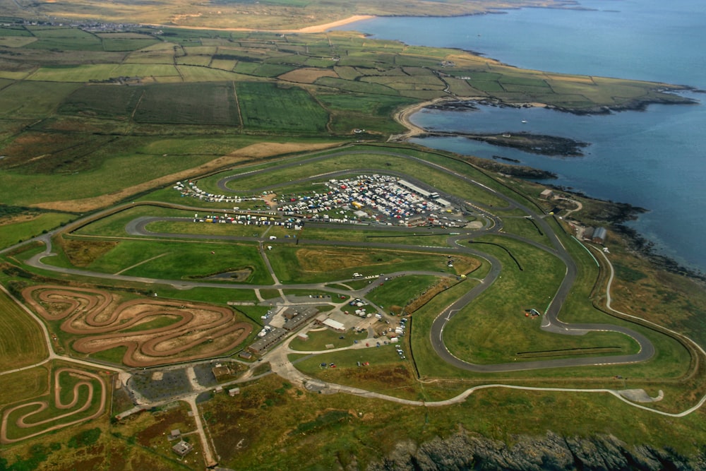 an aerial view of a race track next to a body of water