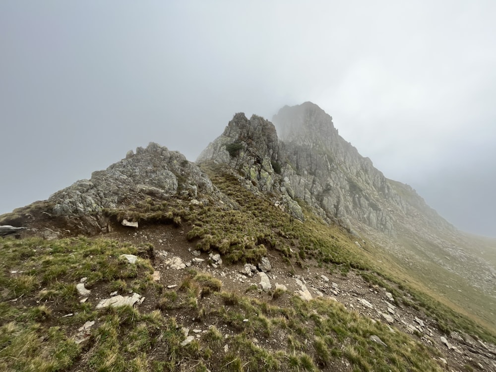 a very tall mountain with some grass on top of it