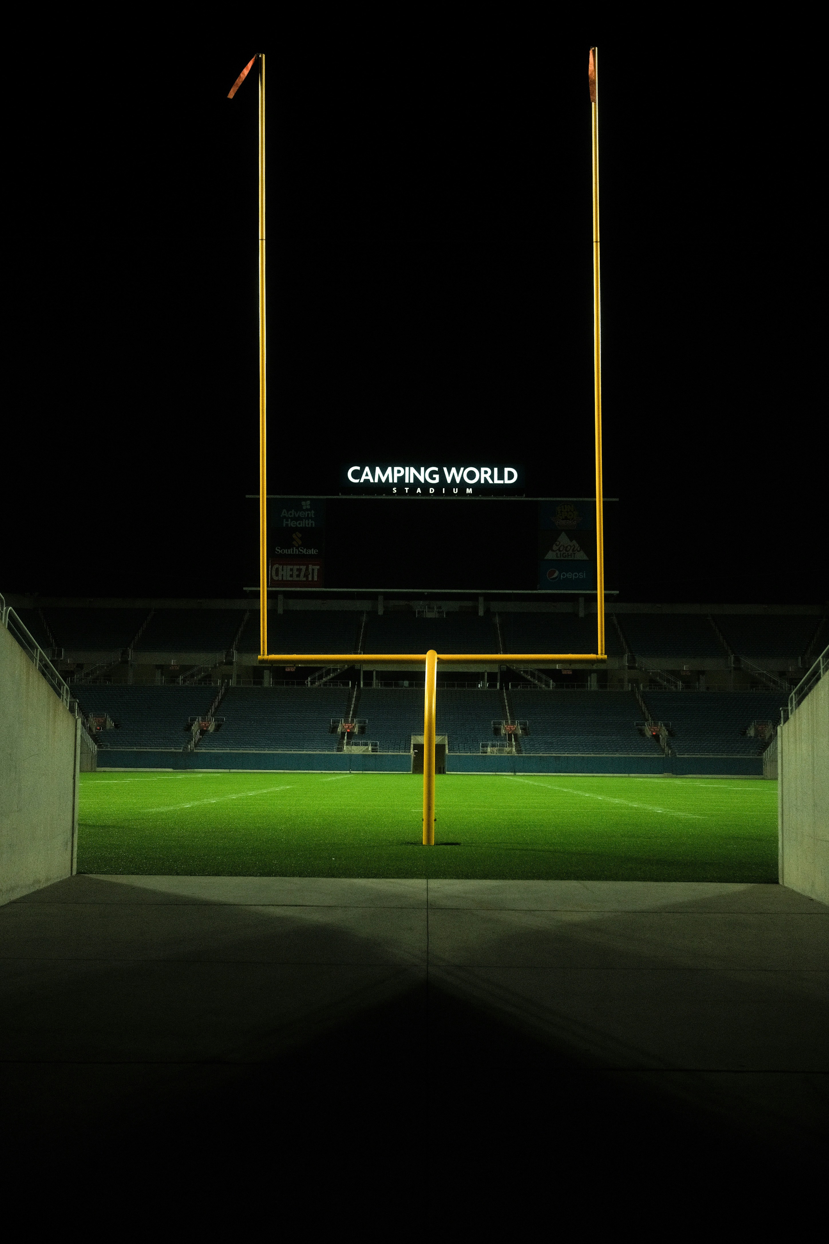 an empty soccer field at night with the lights on