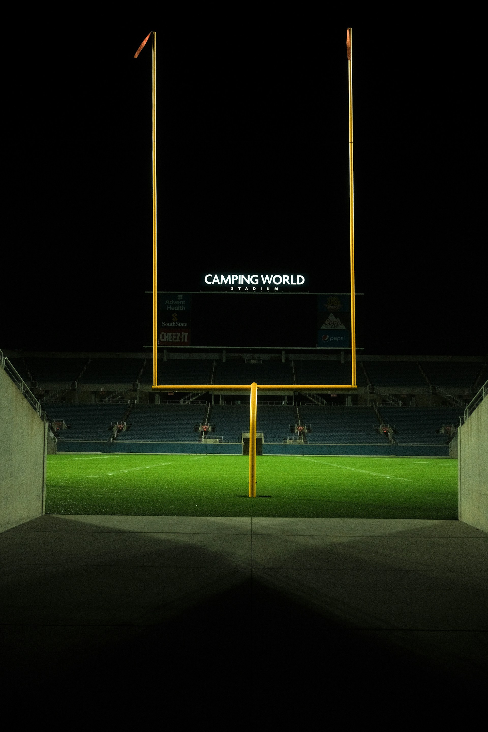 an empty soccer field at night with the lights on