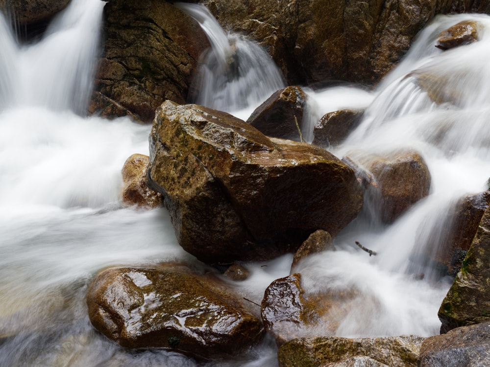 a stream of water running over rocks in a forest