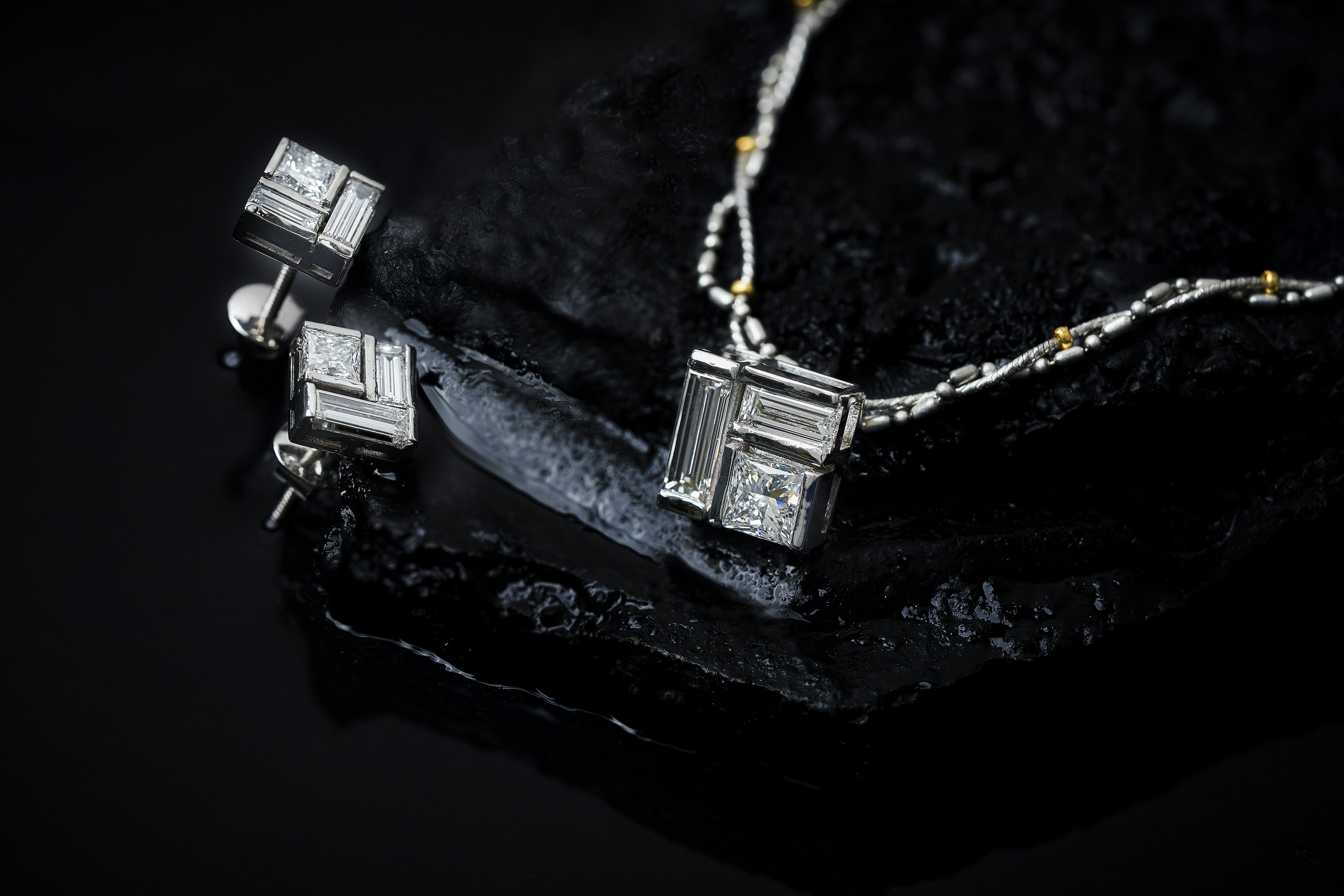 a pair of earrings sitting on top of a rock