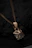 Close-up of a delicate antique gold necklace with intricate floral patterns.
