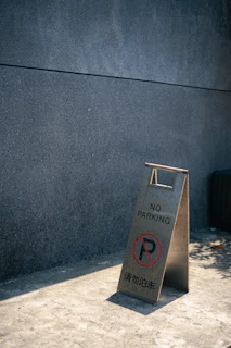 A bright, colorful sign painted in pastel Easter hues with the exact phrase 'the sign is as useless as the no parking sign' prominently displayed.