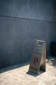 A bright, colorful sign painted in pastel Easter hues with the exact phrase 'the sign is as useless as the no parking sign' prominently displayed.
