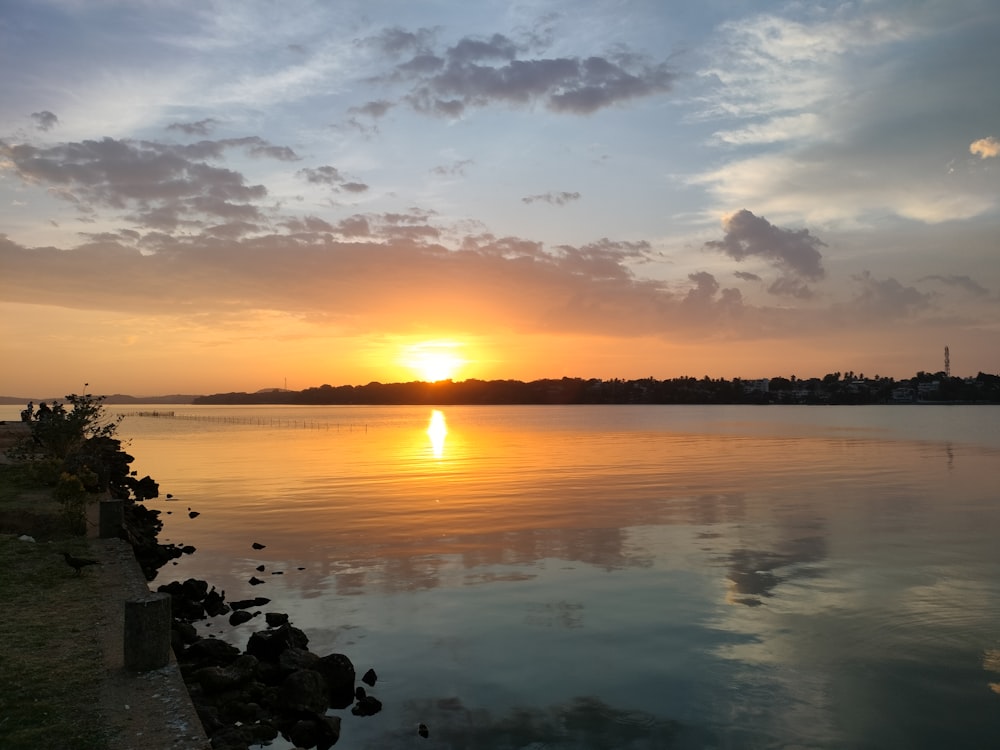 the sun is setting over a body of water