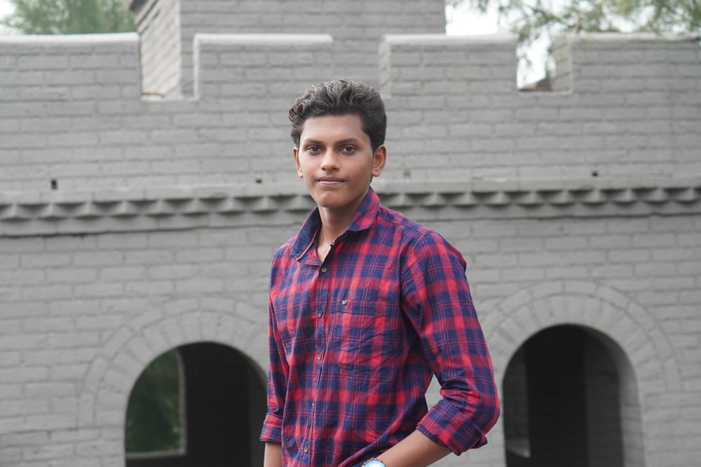 a man standing in front of a brick building