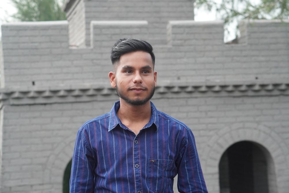 a man standing in front of a brick building