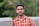 a man in an orange and white checkered shirt