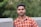 a man in an orange and white checkered shirt