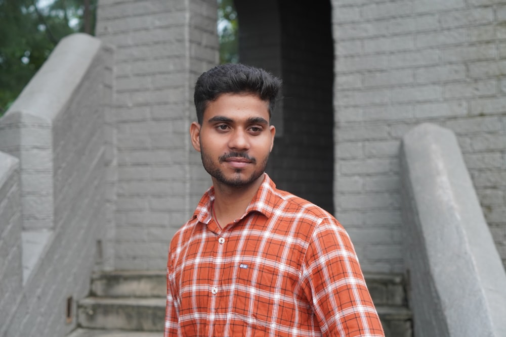 a man standing in front of a brick building