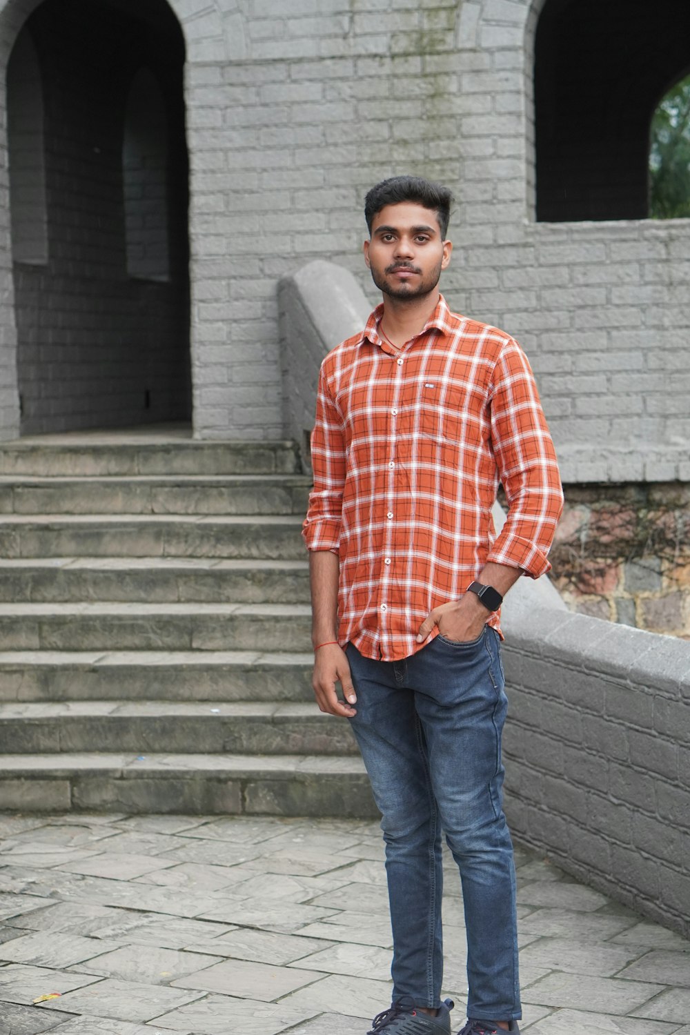 a man standing in front of a brick building