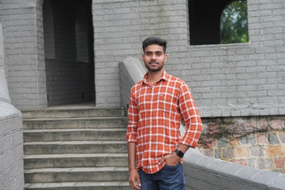 a man standing in front of a brick building