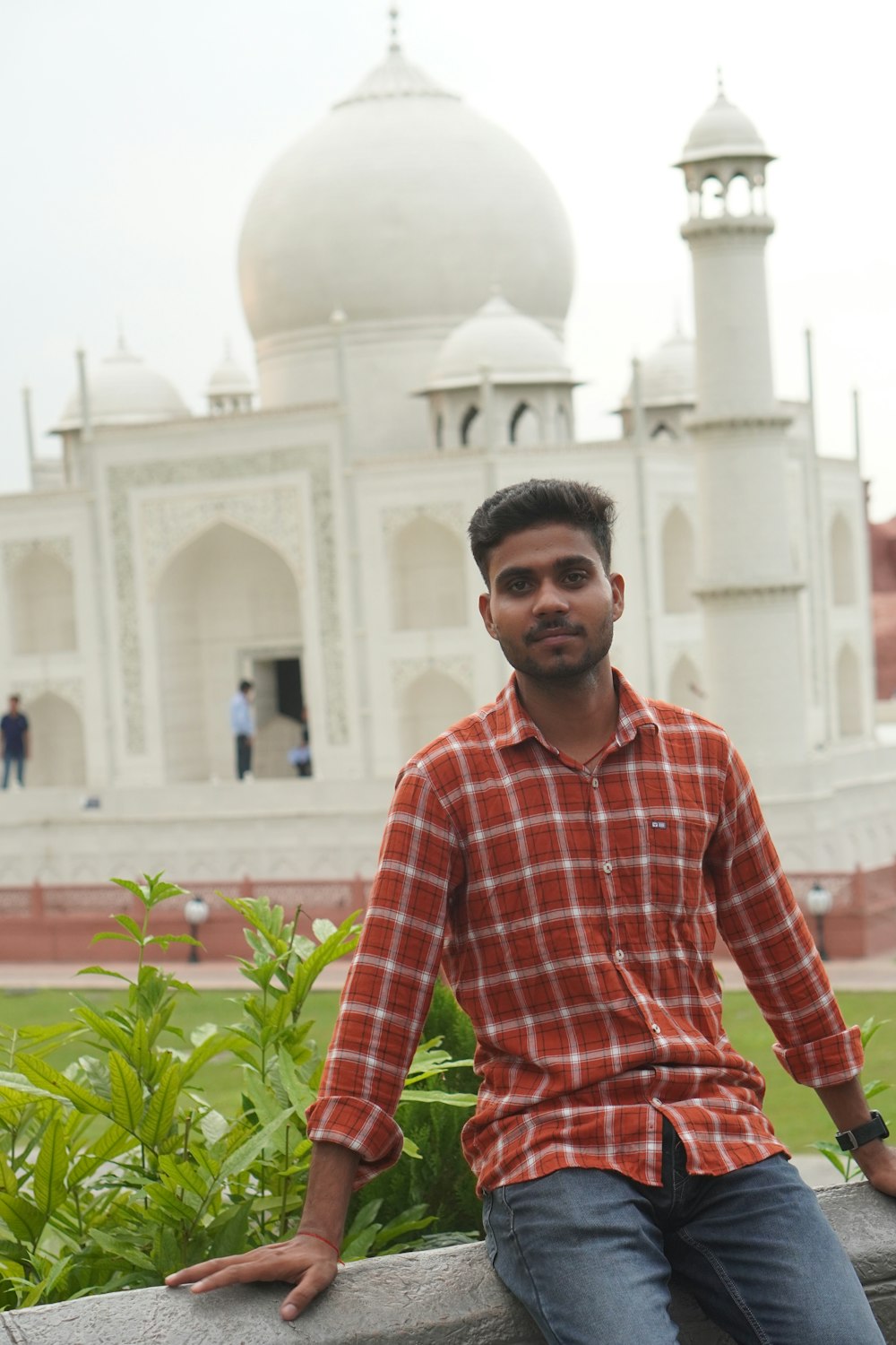 a man sitting on a ledge in front of a building