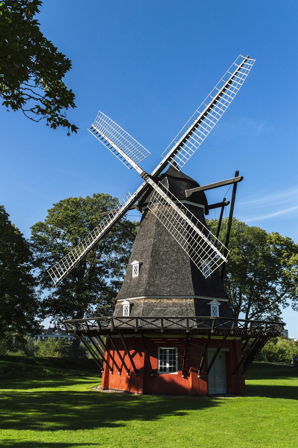 a windmill sitting on top of a lush green field