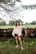A farmer inspecting the herd with a warm smile, surrounded by calves and adult cows.