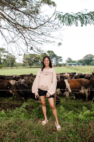 A smallholder farmer feeding dairy cows with Greenflux Biotech’s supplement, smiling proudly.