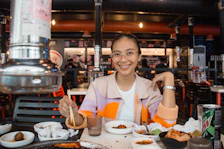 a woman sitting at a table full of food