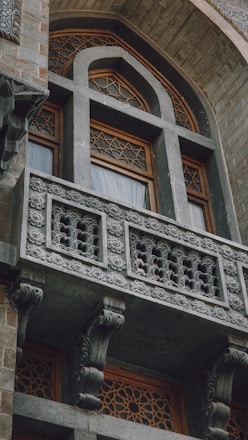 a building with a balcony and a clock on the side of it