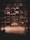 A long warehouse aisle is lined with tall metal shelves filled with large, stacked boxes and pallets. The space is dimly lit, creating a tunnel effect down the aisle with visible symmetry and perspective extending into the distance.