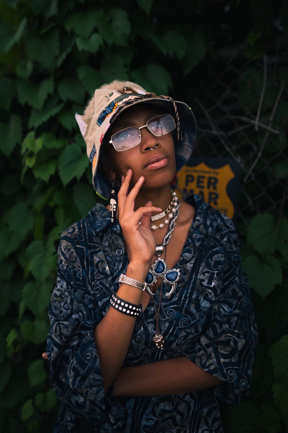 a woman wearing a hat and glasses posing for a picture