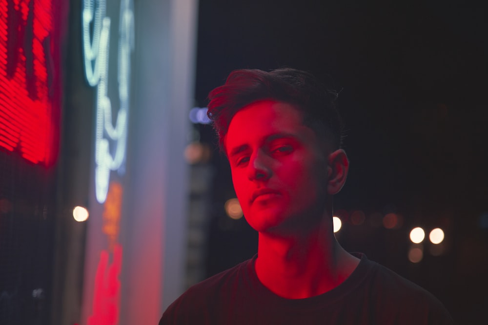 a man standing in front of a neon sign