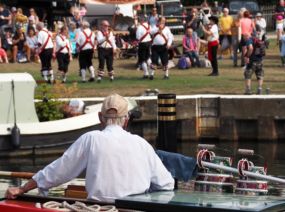 a man sitting on a boat in front of a crowd of people