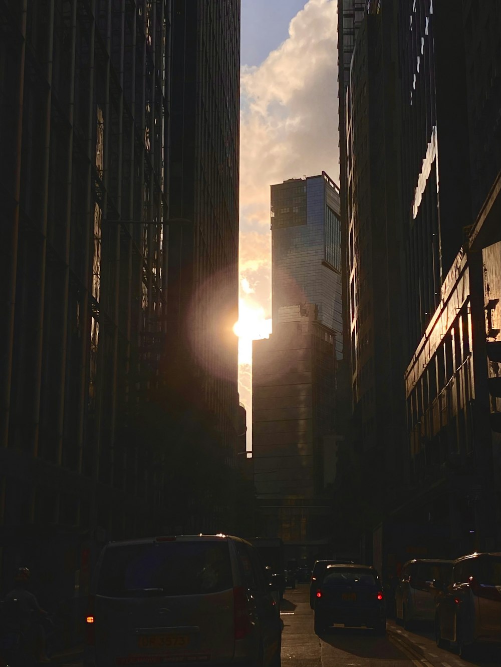 the sun is setting in a city with tall buildings